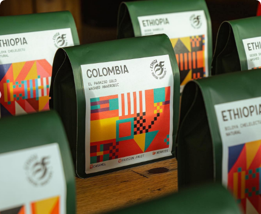 seven bags of ethica specialty coffee on a wooden table